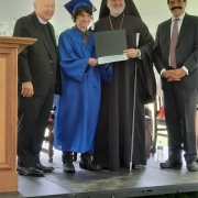 A student receiving a diploma from Saint Basil staff and the Archbishop