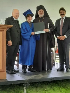 A student receiving a diploma from Saint Basil staff and the Archbishop