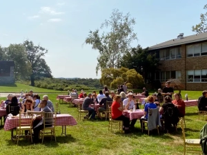 Walk-a-Thon 2022 cookout with people sitting outside at tables on the Saint Basil property