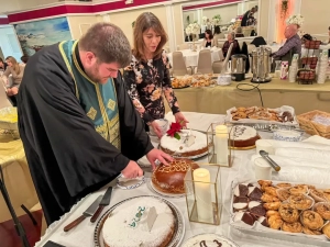 Father Jason from Kimisis Greek Orthodox Church cutting the Vasilopita