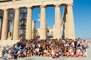 A group of youth from the Ionian Village in front of large ancient looking columns