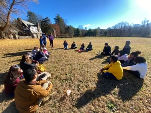 A group of people sitting in a circle on the lawn of Saint Basil Academy