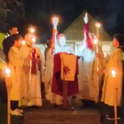 Clergy and alter servers holding candles outside at night for Pascha