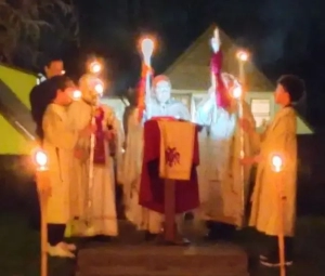 Clergy and alter servers holding candles outside at night for Pascha