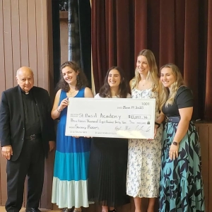A large check held by the District 6 Maids of Athena who fundraised the money for the Saint Basil Sensory Room