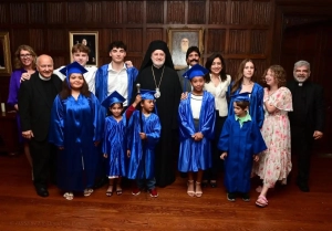 Archbishop Elpidophoros standing with graduates, clergy, and other adults inside Saint Basil.