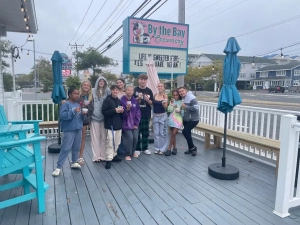 Saint Basil children and youth holding cups and spoons standing on the deck of an ice cream shop.