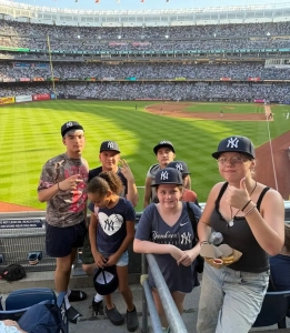 Saint Basil Academy youth standing at a New York Yankees game with the field behind them.