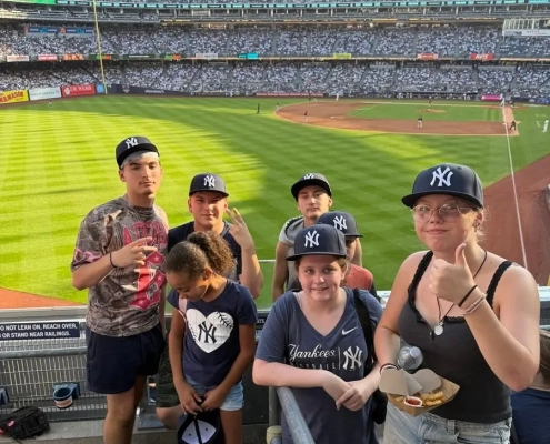Saint Basil Academy youth standing at a New York Yankees game with the field behind them.