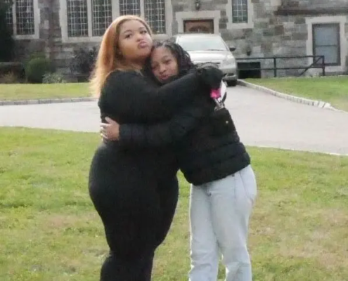 Two girls hugging each other outside of Saint Basil Academy