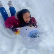 A girl sledding in the snow