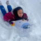 A girl sledding in the snow