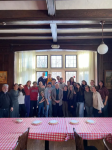 A group of youth with Father Costa and Deacon Kyriakos with Vasilopita on the table in front of them