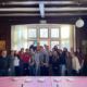 A group of youth with Father Costa and Deacon Kyriakos with Vasilopita on the table in front of them