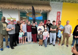 A group of people with a man in the middle holding a folded American flag