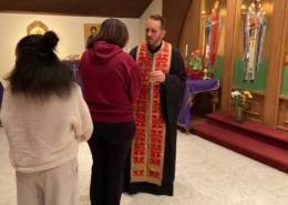 Father Nikolas Belaveris ministering to a youth during a parklesis service at Saint Basil Chapel
