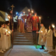 Two priests with the gospel and alter servers holding candles outside in the dark during the Holy Pascha service 2026