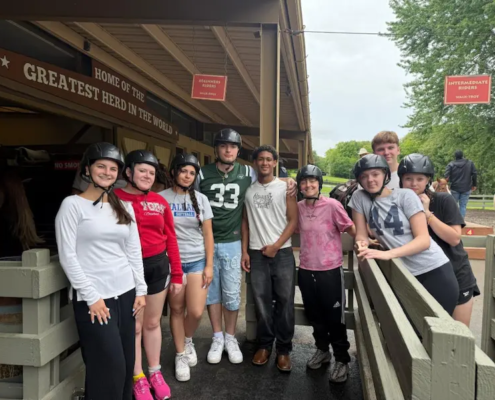 Saint Basil Academy youth at on a trip to Rocking Horse Ranch standing outside the stables.