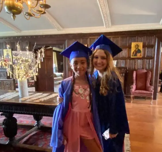 Saint Basil Academy graduates Two graduates of Saint Basil Academy wearing cap and gown smiling