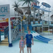 A boy and a girl standing in shallow water at the Splash Down Beach water park.