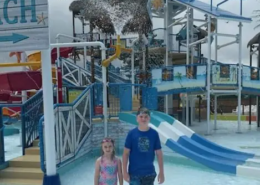 A day at Splash Down Beach water park A boy and a girl standing in shallow water at the Splash Down Beach water park.