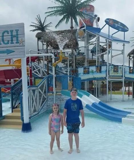 A day at Splash Down Beach water park A boy and a girl standing in shallow water at the Splash Down Beach water park.
