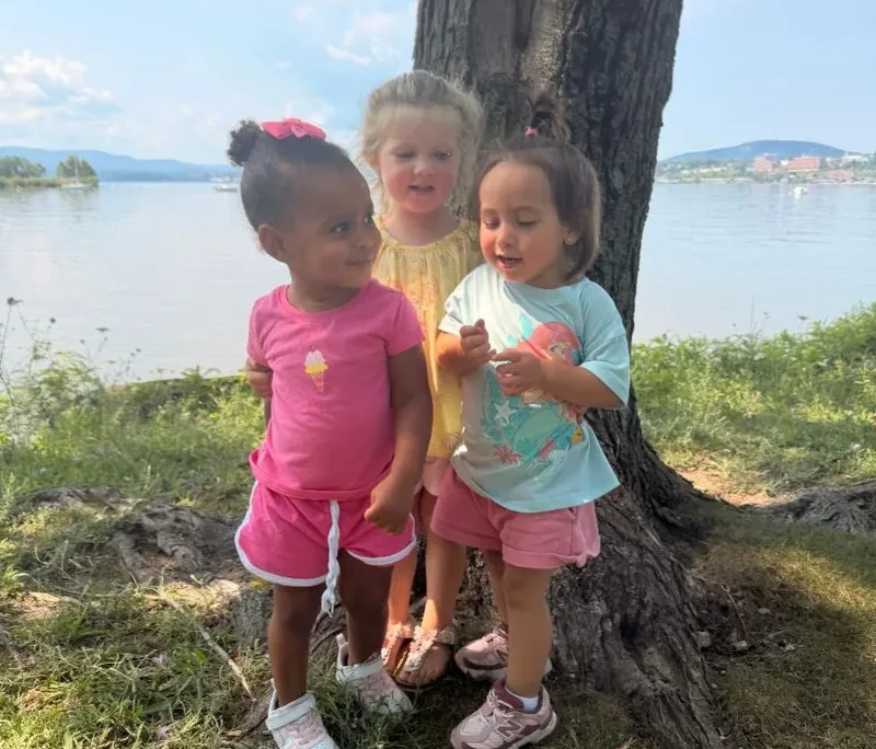 Girls on Saint Basil Academy campus Three young girls standing in front of a tree on the Saint Basil property with the Hudson River in the background.
