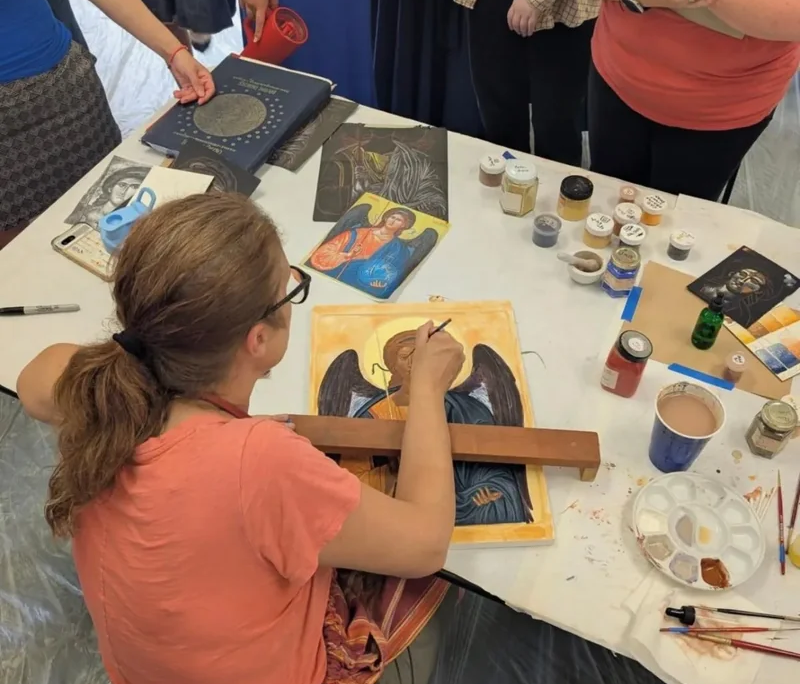 Icon painting retreat at Saint Basil Academy A woman painting an icon of Archangel Michael at an icon painting retreat at Saint Basil Academy.