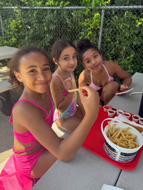 Girls on an outing Three girls eating french fries at a picnic table