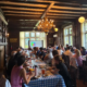 Saint Basil Academy staff sitting at two long adjacent tables with a projector screen at the far end of the room.