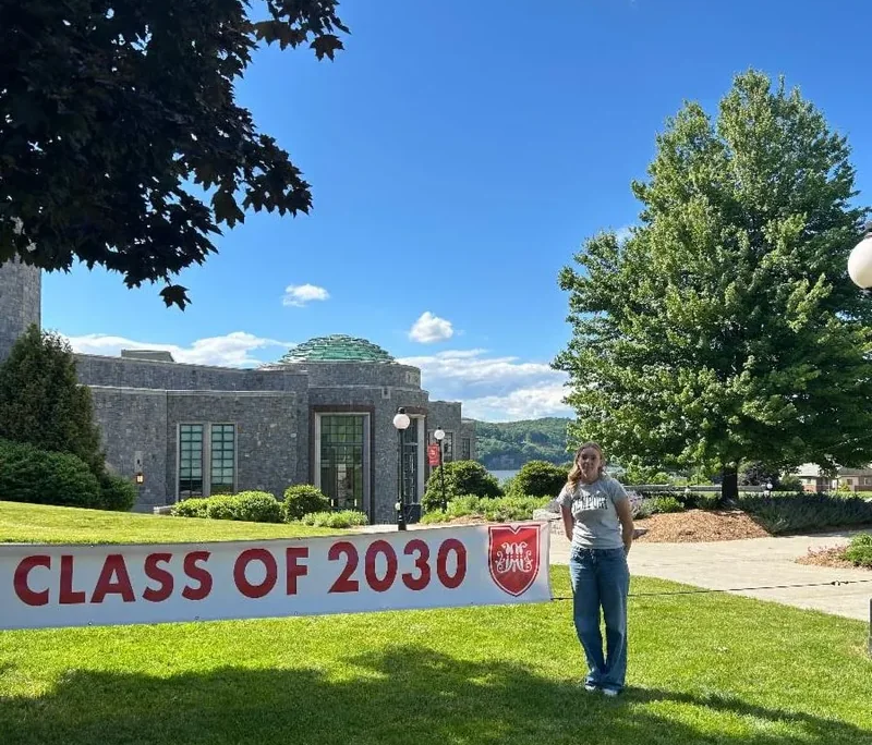 A new school year begins A Saint Basil female youth standing on a lawn with a sign that says, "Class of 2030."