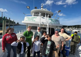 Fishing trip Children from Saint Basil Academy smiling with adults on the deck of the Celtic Quest IV during a fishing trip