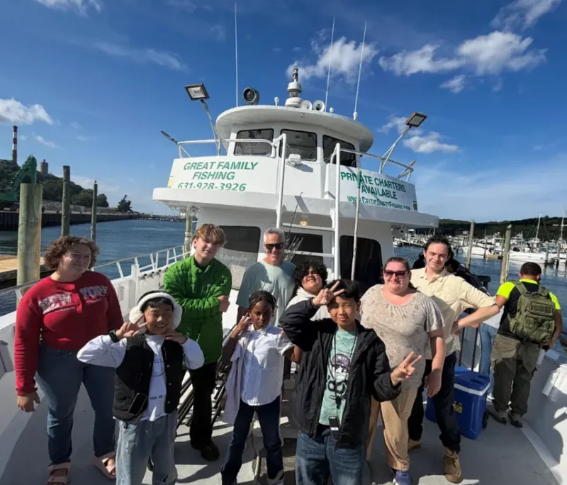 Fishing trip Children from Saint Basil Academy smiling with adults on the deck of the Celtic Quest IV during a fishing trip