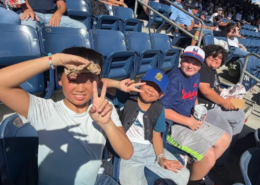 Yankees baseball game Four smiling boys sitting in the stands at a Yankees baseball game